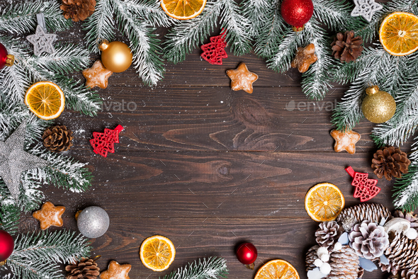Christmas greeting card with decor and fir tree branch on a dark wooden  background. Top view with Stock Photo by lyulkamazur