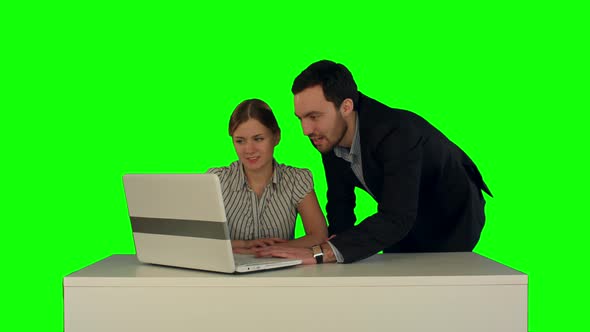Business People Having Meeting Around Table with Laptop on a Green Screen alt