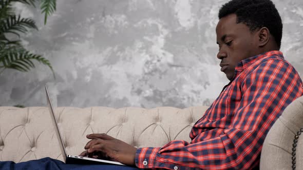 African American Businessman Works Laptop Online Chatting with Company Employees alt