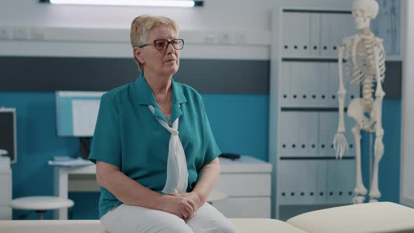 Portrait of Elder Woman Sitting in Medical Office at Checkup Visit alt