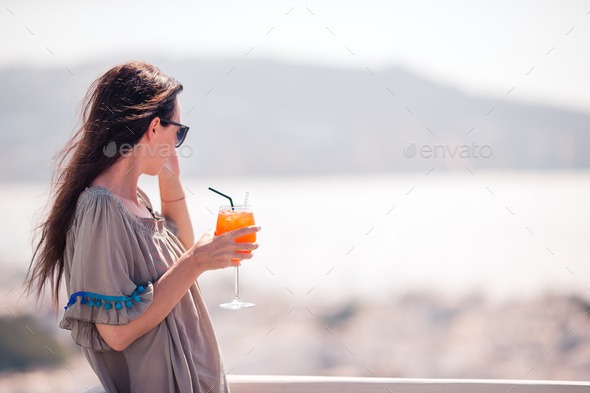 Young happy woman in outdoor cafe with tasty drink - Stock Photo - Images