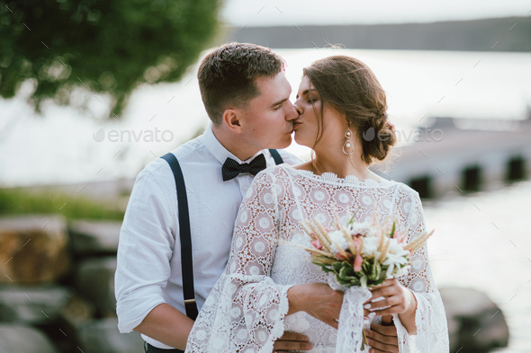 Happy newly married kissing couple, smiling bride brunette young woman with groom - Stock Photo - Images
