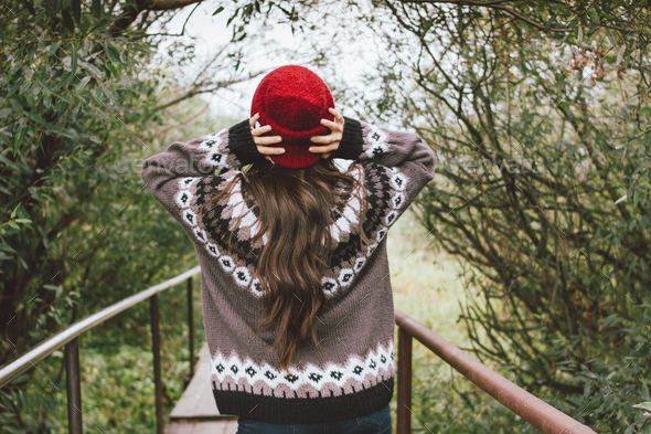 Long hair asian girl in red hat and knitted nordic sweater in autumn nature park - Stock Photo - Images