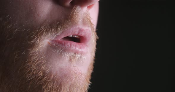 Breathing man mouth close-up slow motion, studio shot in 4K prores HQ