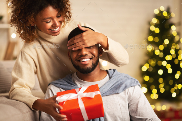 Xmas surprise. Loving wife giving gift to husband