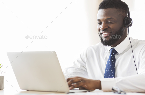 Young business consultant typing email to client on laptop
