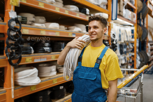 Male builder with coil of wires in hardware store