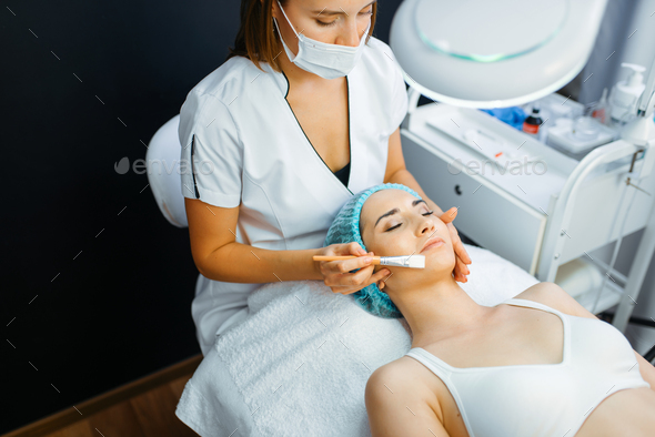 Cosmetician with brush cleans facial skin - Stock Photo - Images