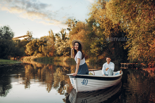 Pretty lady poses in boat on quiet lake