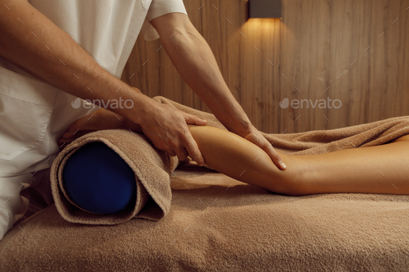Male masseur stretching legs to young woman - Stock Photo - Images
