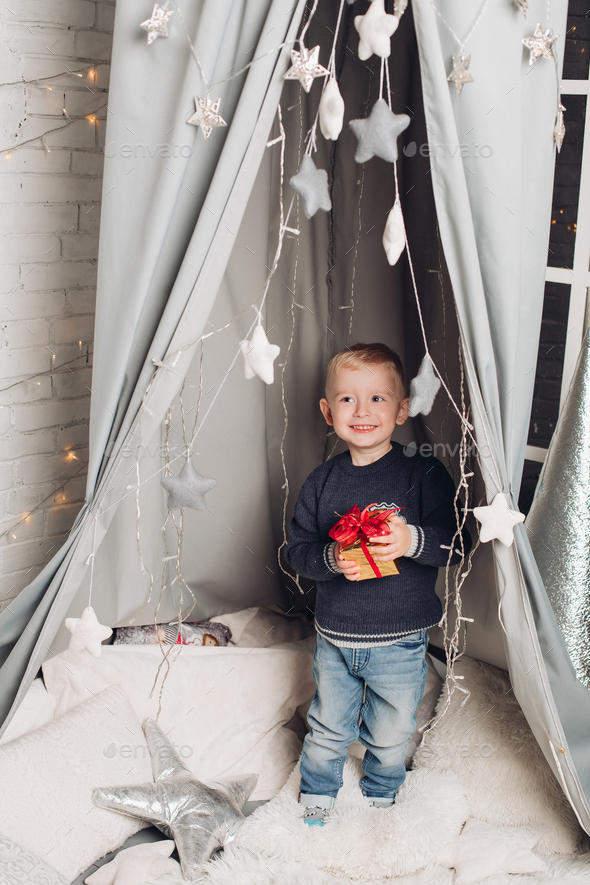 Portrait boy shows Christmas boxes with gifts - Stock Photo - Images