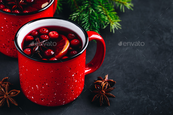 Traditional Christmas Mulled Wine drink with cranberries, orange slices and spices in red mugs - Stock Photo - Images