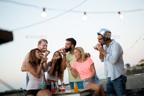 Carefree group of friends enjoying party on rooftop