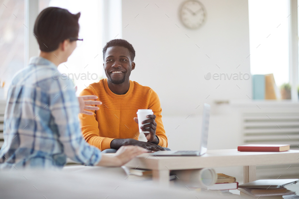 Smiling African Man Talking to Colleague in Office
