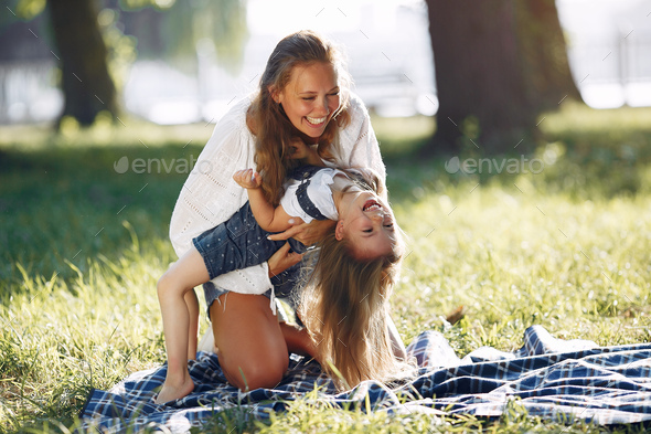 Mother with daughter playing in a summer park