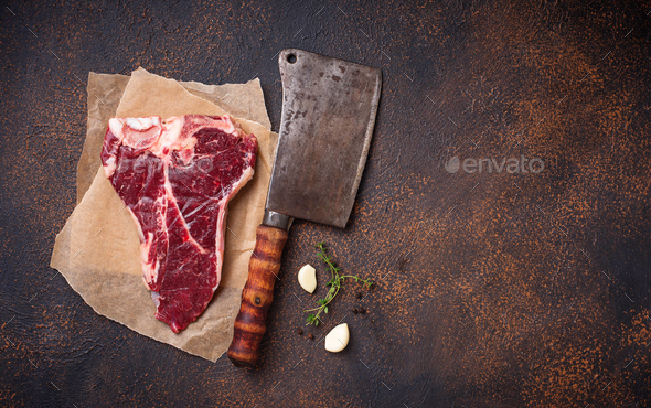 Raw T-bone steak with butchers knife