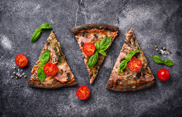 Pieces of black pizza with tomatoes and basil