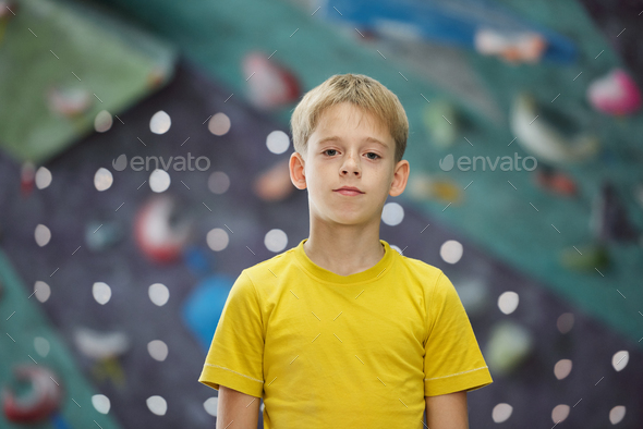 Active boy of elementary age standing in front of camera while standing in gym - Stock Photo - Images
