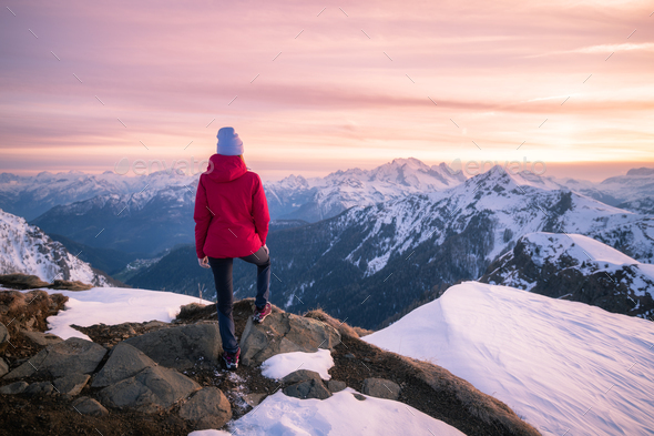 Young woman in snowy mountains at sunset in winter - Stock Photo - Images