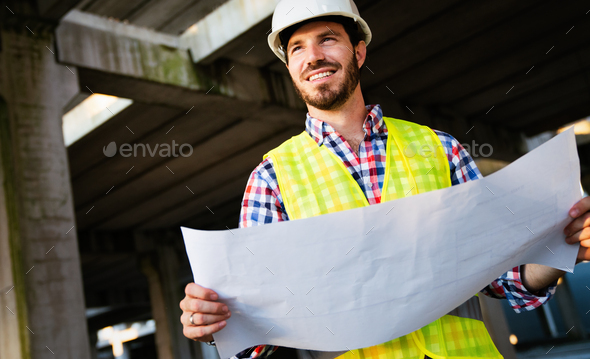 Picture of construction site engineer looking at blueprint