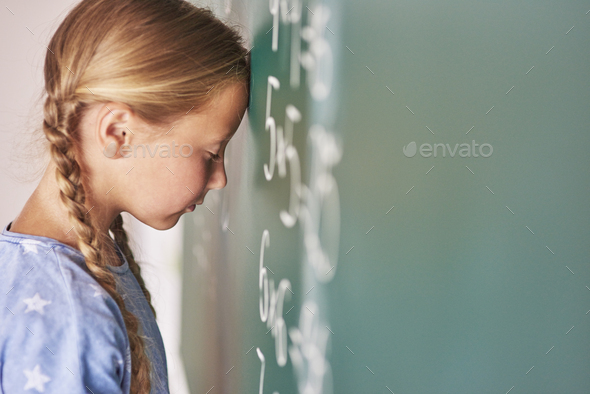 Schoolgirl trying to understand formula - Stock Photo - Images