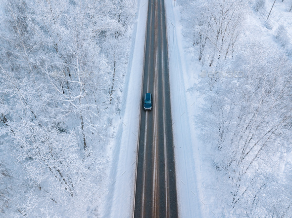 Aerial view of a winter road with snow forest
