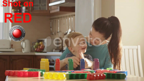 Happy Family of Mother Teaching Little Boy How To Count Using Colored Blocks Using Educational Games alt