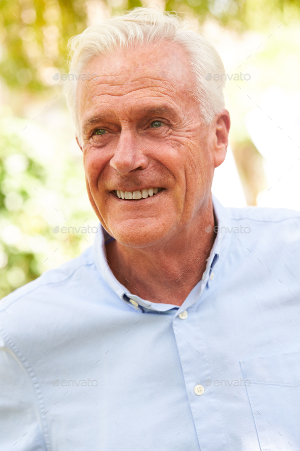 Outdoor Portrait Of Smiling Senior Man In Garden At Home