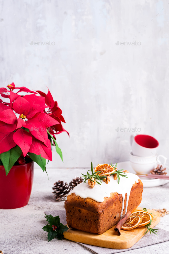 Fruit loaf cake dusted with icing, nuts and dry orange on stone background. Christmas and Winter - Stock Photo - Images