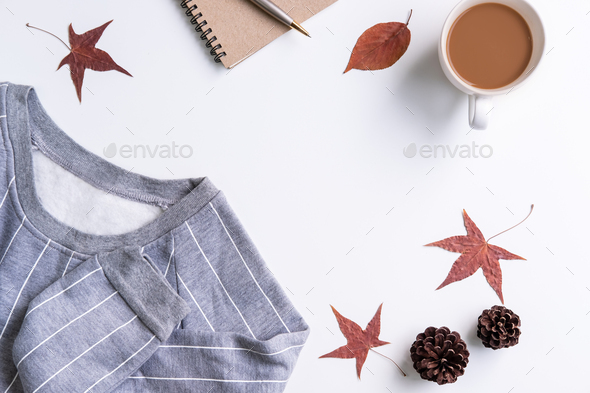 Cup of coffee with dried autumn leaves and sweater, Top view