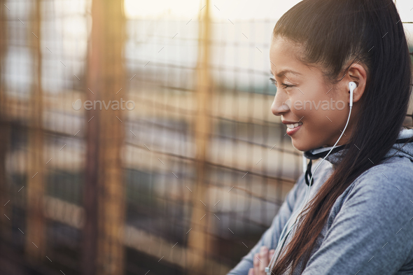 Asian woman listening to music while out for a run - Stock Photo - Images