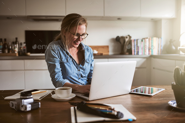 Smiling young woman working from home with a laptop