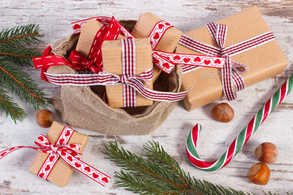Gifts for Christmas or Valentines in jute bag and spruce branches - Stock Photo - Images