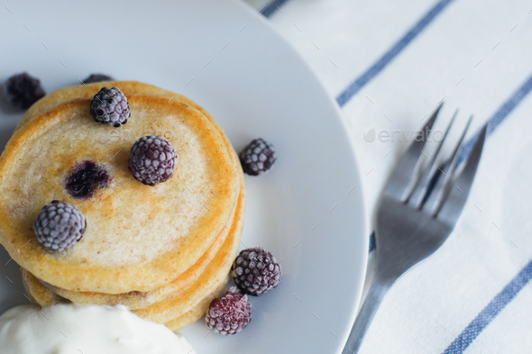 fritter or pancakes with black raspberry with sour cream on dish - Stock Photo - Images