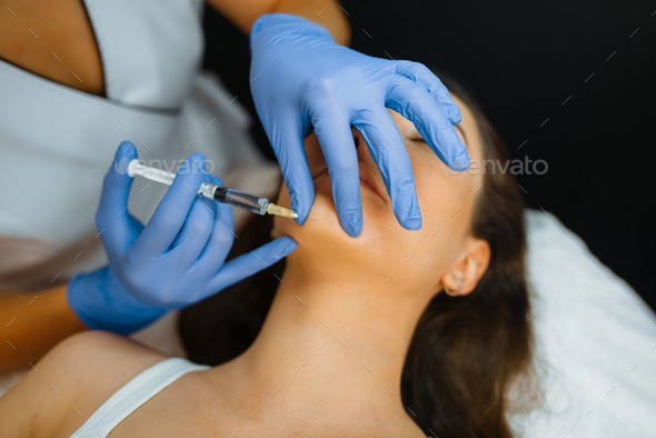 Cosmetician gives chin botox injection to patient - Stock Photo - Images