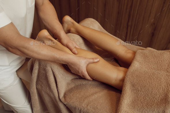 Masseur pampering legs to woman, closeup view - Stock Photo - Images