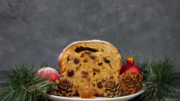 Powdered sugar poured onto Christmas Stollen fruit cake on dark background Festive pastry baking 4K alt