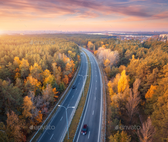 Aerial view of road in beautiful autumn forest at sunset - Stock Photo - Images