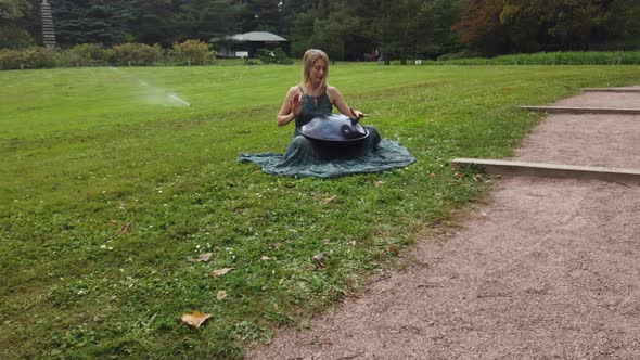 Beautiful Young Woman Plays a Hang in the Autumn Park alt