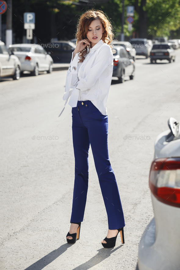Slim stylish brunette girl dressed in white shirt and blue