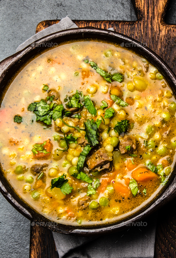 Traditional chilean carbonara. Stewed beef with pumpkin, potatoes and vegetables in clay bowl - Stock Photo - Images