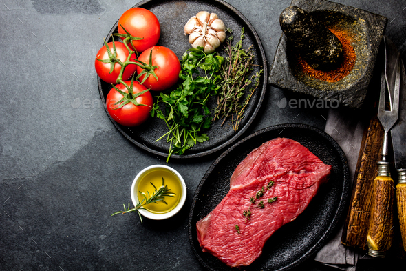 Fresh raw meat beef steak. Beef tenderloin, spices, herbs and vintage cutlery - Stock Photo - Images