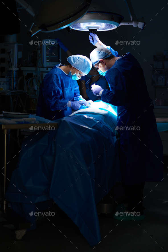 Operation in the dark operating room - Stock Photo - Images