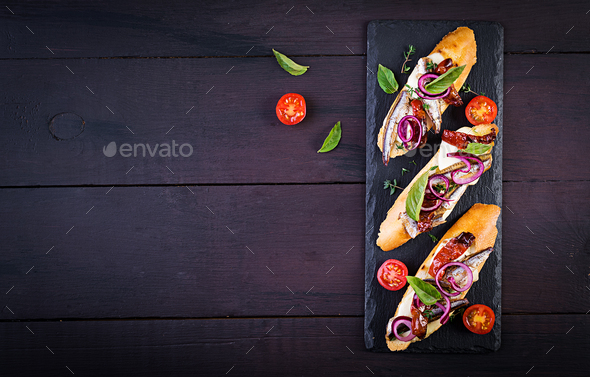 Bruschetta with slices of sun-dried tomatoes,cheese mozzarella and anchovies - Stock Photo - Images