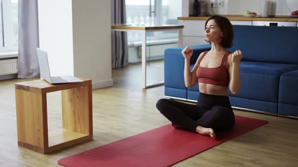 Woman Practicing Yoga with Trainer Via Video Conference  Warming Up Hands alt