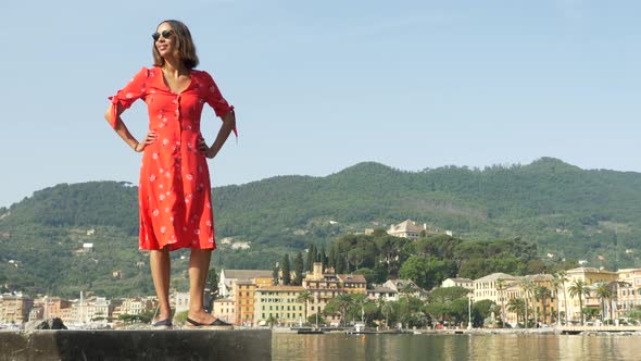 A woman in a red dress traveling in a luxury resort town in Italy, Europe alt