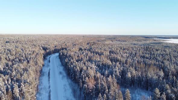 Aerial View From a Drone of a Road in the Middle of Snowcovered Trees and Snowcovered Forest on a