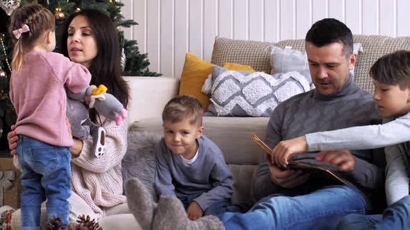 Family with Three Children is Spending Time Together at Home in Christmas Eve