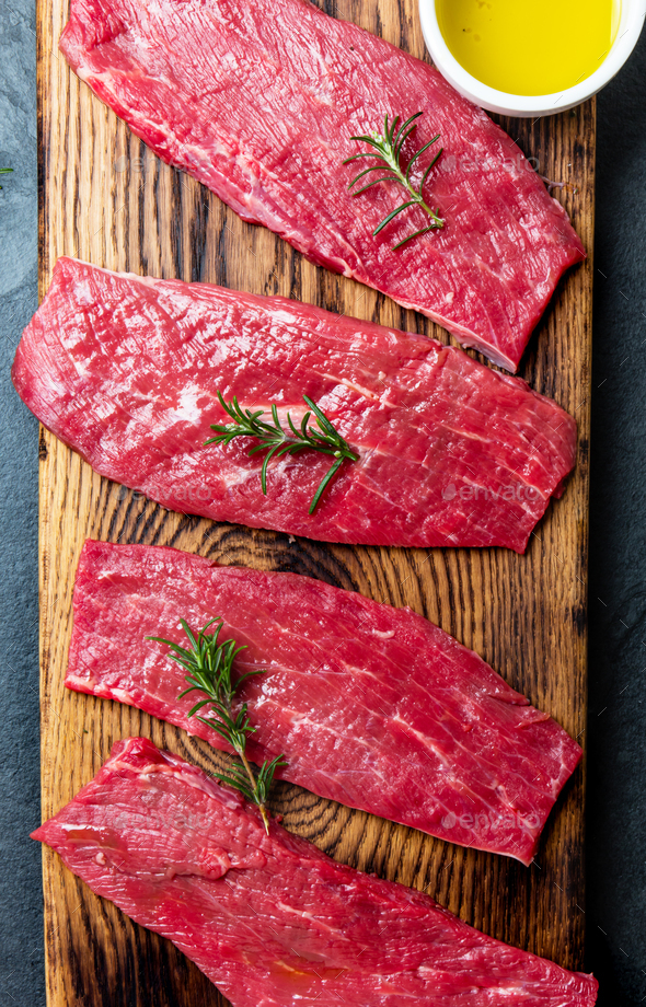 Fresh raw meat beef steaks. Beef tenderloin on wooden board, spices, herbs, oil - Stock Photo - Images