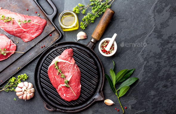 Beef Tenderloin and marbled beef steaks on grill pan and frying board with seasoning - Stock Photo - Images